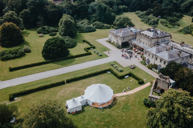 one pole tent with catering marquee and matted walkway. Set up in the grounds of a stately home for a wedding. wedding breakfast and dancing in the marquee with the caterers in the china hat tents attached to the main pole tent.