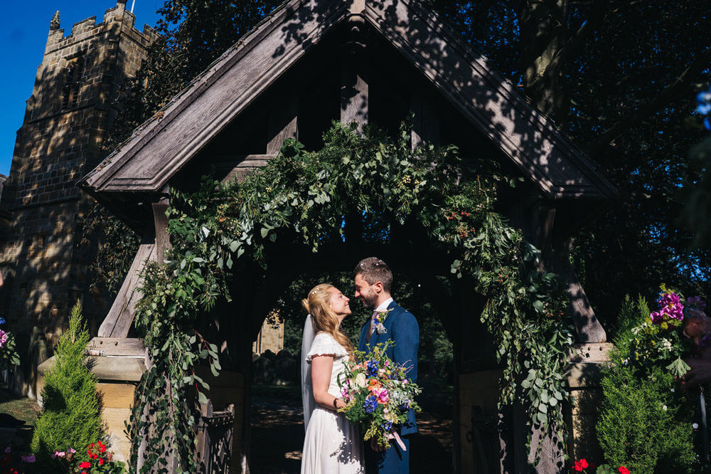 Wedding couple under a flower archway