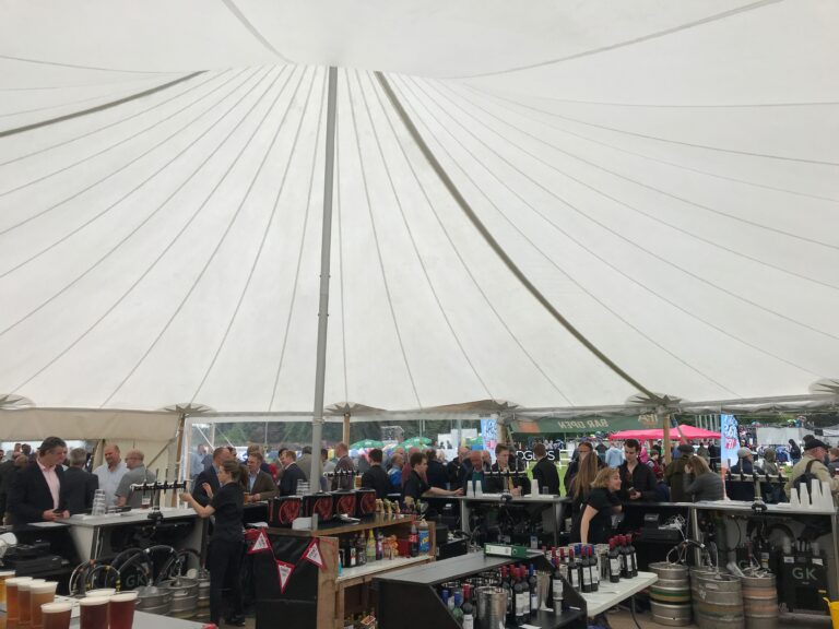 Two pole sailcloth tent set up for a bar at a corporate event in Yorkshire. High peaks and white canvas.