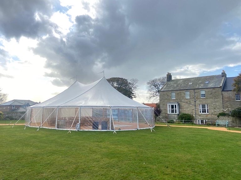 marquee set up in the grounds of a family home. wedding in the marquee.